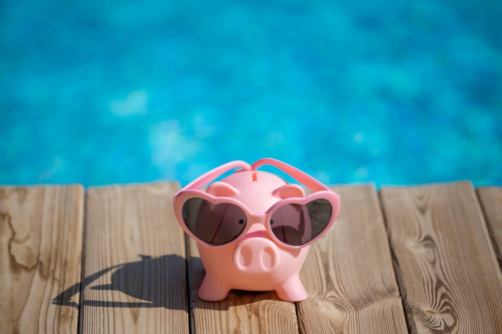 Piggybank on wood against blue water background
